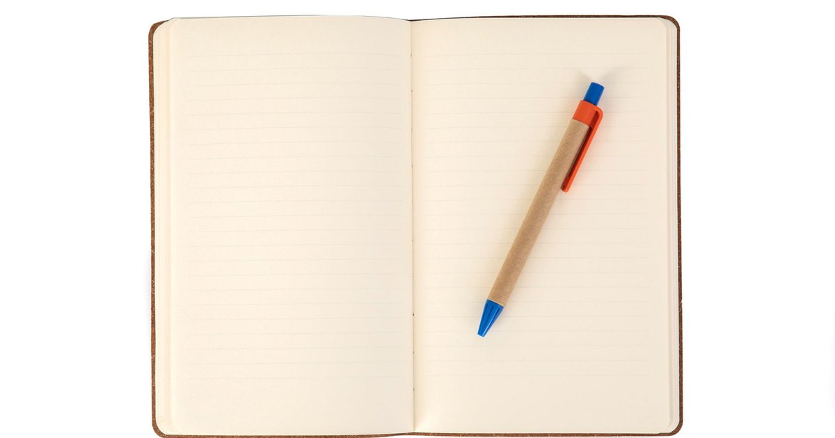 A minimalistic image featuring an open notebook with a pen placed on its pages, offering ample copy space.