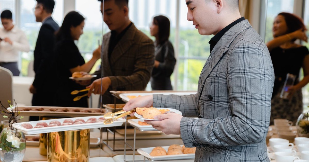Businesspeople enjoying a buffet at a corporate event with diverse food options.