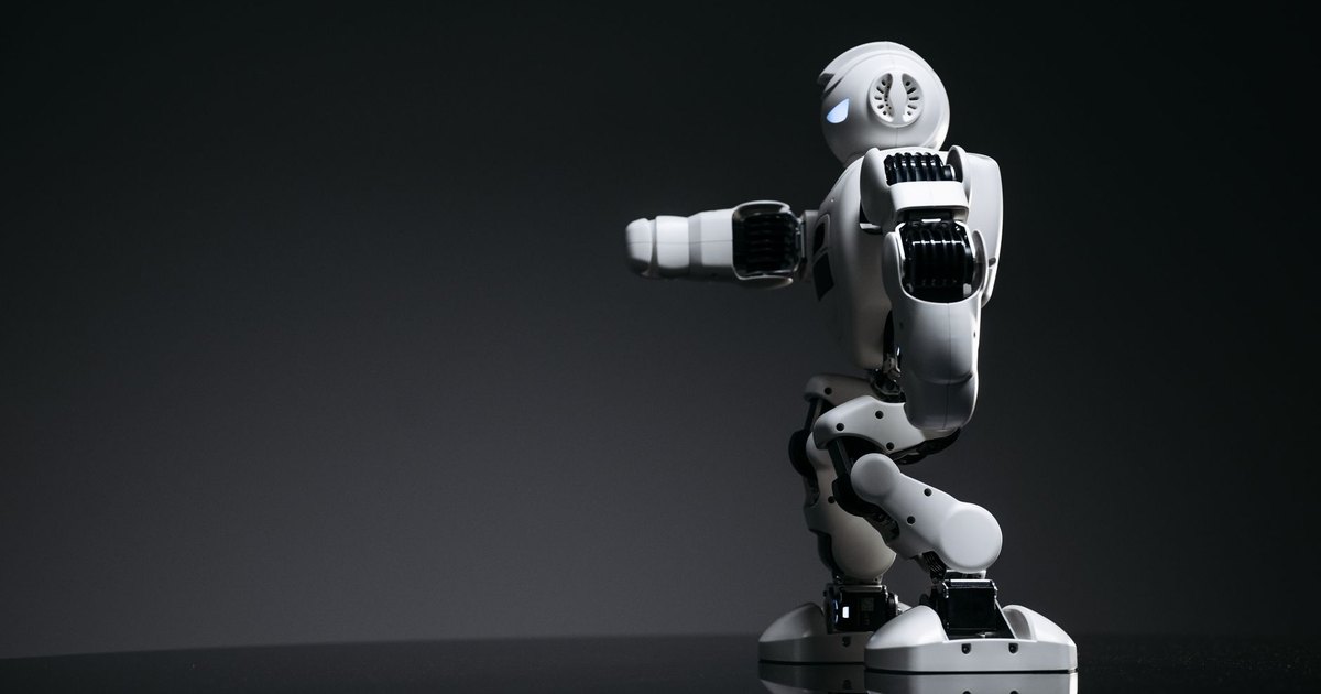 A white robot showcasing modern design on a sleek dark surface.