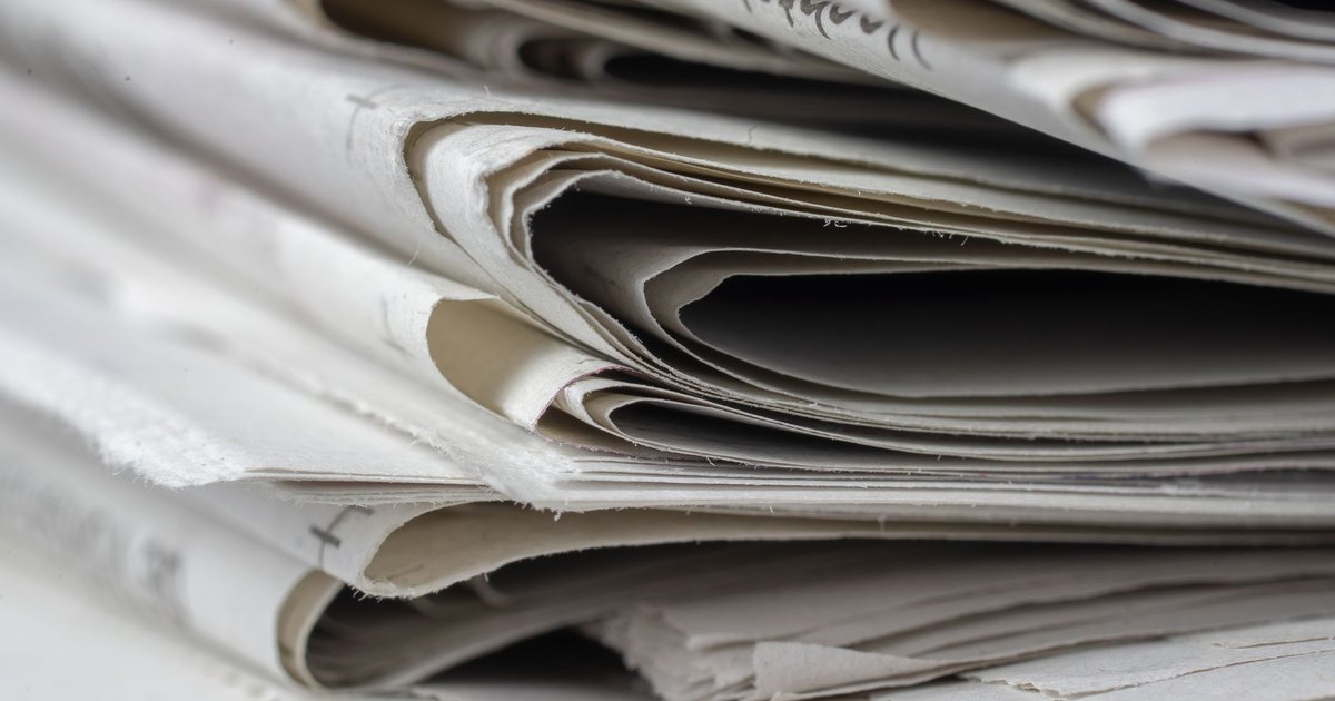 A detailed close-up view of stacked newspapers, highlighting textures and layers.