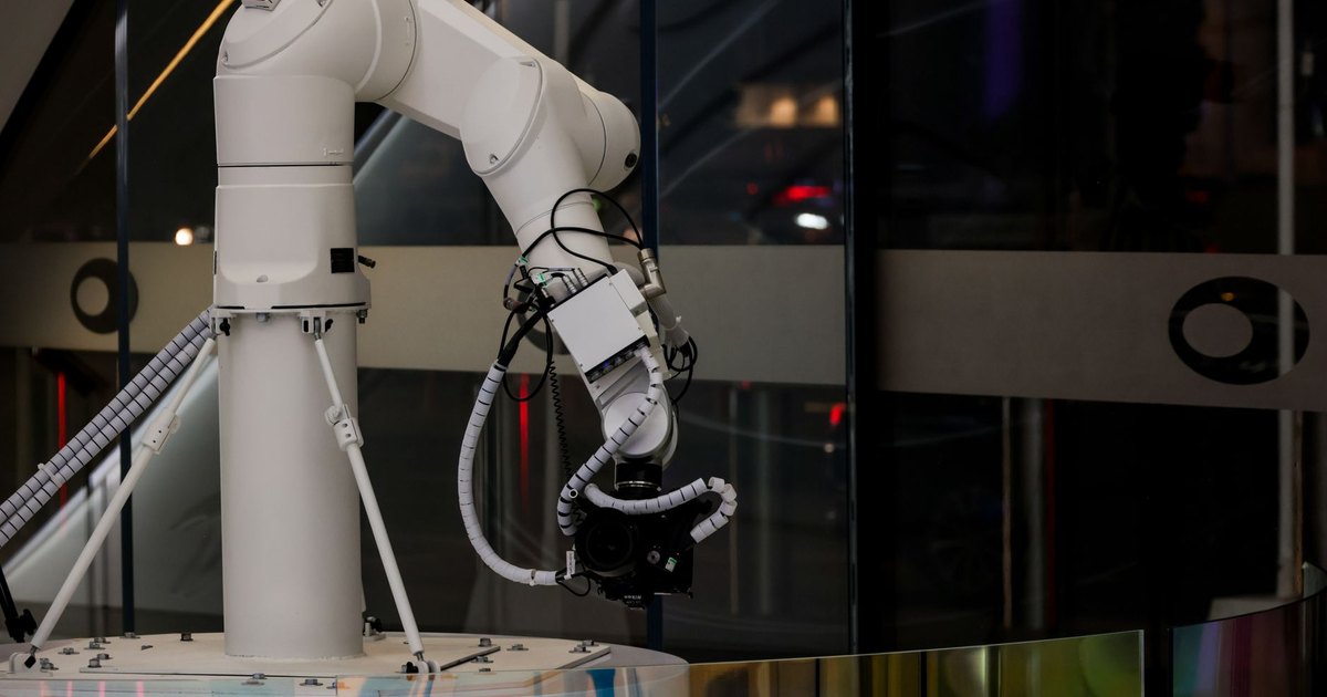 A white robotic arm operating indoors with a modern design and advanced technology.