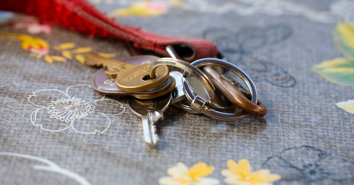 A set of keys lying on a floral-patterned fabric background. Ideal for security themes.